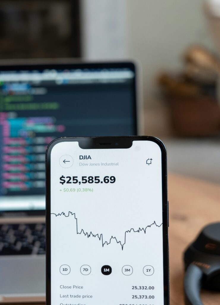 A phone screen with prices and graphs displayed over it.